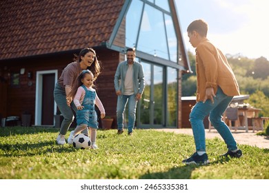 Happy parents and their kids playing with a ball and having fun during family day outdoors.  - Powered by Shutterstock