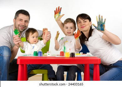 Happy Parents With Thier Childern Enjoy Painting With Assorted Colours On Hands