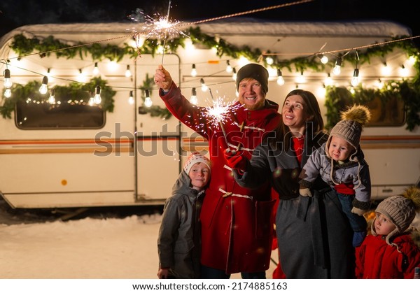 Happy parents with three sons celebrating christmas in\
motorhome. 