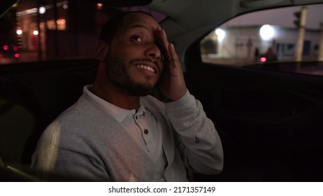 Happy Passenger Inside Taxi Cab In Backseat Vehicle At Night. One Happy Black Guy Commuting Looking Out Car Window Smiling