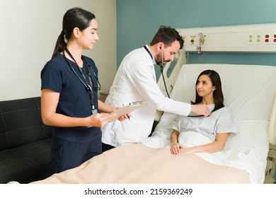 Happy Patient Feeling Better After A Medical Surgery At The Hospital. Doctor And Nurse With A Woman Checking Vital Signs