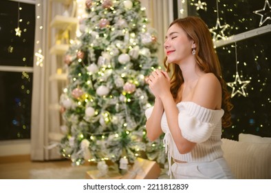 Happy Peaceful Beautiful Asian Woman With Appealing Smile And Closed Eyes Keep Hands Folding In Prayer For Christmas In Church Concept For Faith, Christmas Spirituality And Religion. Thank You My God.