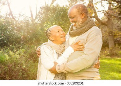 Happy peaceful senior couple embracing in parkland