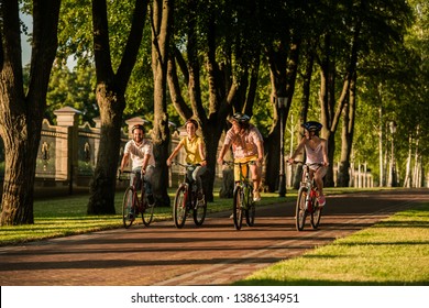 Happy People Biking Outdoors. Group Of Friends Enjoying Summer Vacation. Students Are Travelling By Bikes.