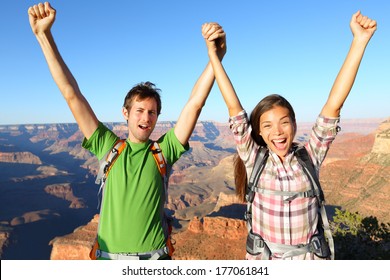 Happy People Celebrating Cheering In Grand Canyon. Young Multiethnic Couple On Hiking Travel Excited And Elated In Grand Canyon, South Rim, Arizona, USA. Asian Woman And Caucasian Man.