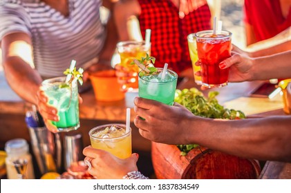 Happy People Cheering With Mojito And Having Fun - Multiracial Friends Drinking Coktails In A Beach Bar Outside In Summer Days With Face Mask On To Be Protected From Coronavirus