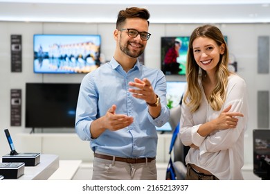 Happy People In Consumer Electronics Retail Store Looking At New Digital Device