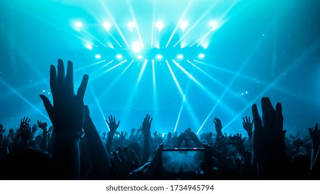 Happy People Dance In Nightclub DJ Party Concert And Listen To Electronic Dancing Music From DJ On The Stage. Silhouette Cheerful Crowd Celebrate New Year Party 2020. People Lifestyle DJ Nightlife.