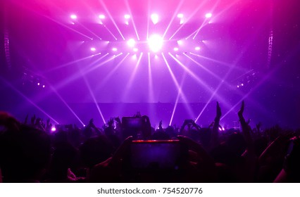 Happy People Dance In Nightclub Party Concert And Listen To The Music From DJ On The Stage In The Background.