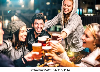 Happy people drinking beer at brewery bar out doors - Multicultural life style concept with genuine friends enjoying time together at open air restaurant patio - Vivid filter with focus on guy