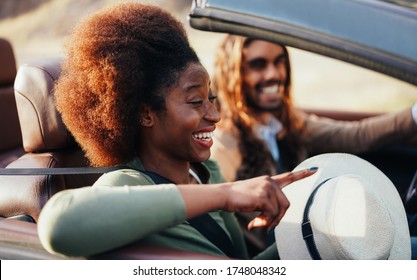 Happy People Having Fun In Convertible Car In Summer Vacation - Young Couple Enjoyng  Holiday On Cabriolet Auto Outdoor - Travel, Youth Lifestyle And Wanderlust Concept - Focus On Afro Girl Eye