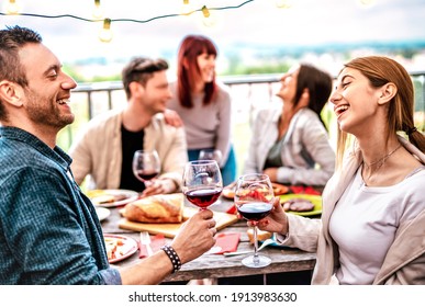 Happy People Having Fun Drinking Wine On Terrace At Private Dinner Party - Young Friends Eating Barbeque Food At Restaurant Together - Dinning Lifestyle Concept On Warm Filter - Focus On Right Glass