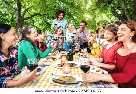 Happy people having fun toasting wine out side - Diverse friends sharing harvest together at farm house vineyard countryside - Food life style concept - Warm vivid filter with focus on central frame