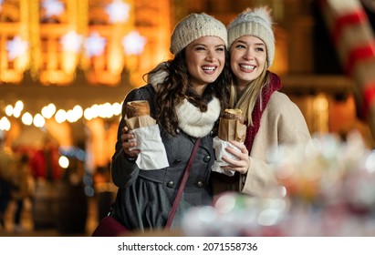 Happy people having fun together at a festive christmas fair. Christmas holiday people concept - Powered by Shutterstock