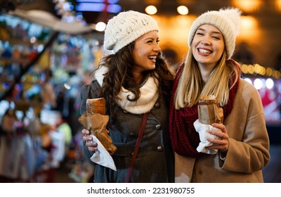 Happy people having fun together at a festive christmas fair. Christmas holiday people concept - Powered by Shutterstock