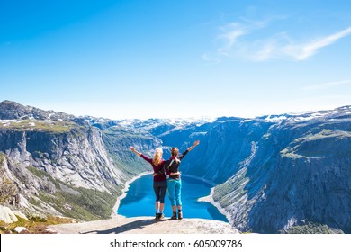 Happy People Relax In Cliff During Trip Norway. Trolltunga Hiking Route