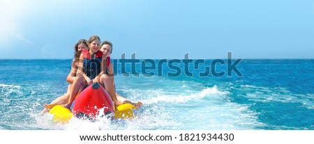 Happy people ride on banana boat . Summer vacation banner