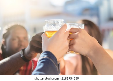 Happy people toasting with beer at brewery bar out doors - Young friends having fun together at happy hour - focus on glass - Powered by Shutterstock