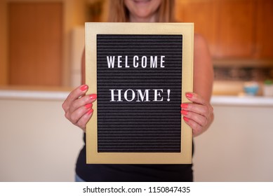 Happy Person Holding Welcome Home Sign