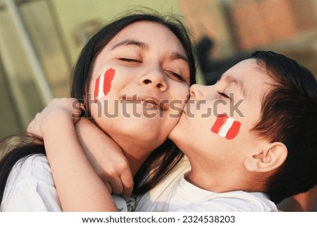 Happy peruvian kids with colors of peruvian flag on the cheek.