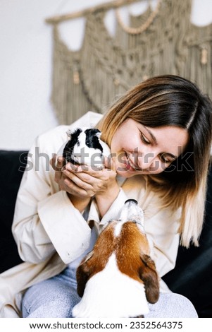 Happy pet owner with guinea pig and dog. Jack russel terrior with owner. Adopt a pet concept.