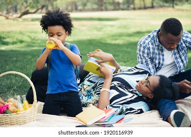 Happy Picnic Black People Family With Son Drink Orang Juice In Garden 