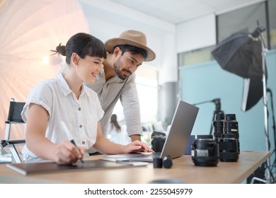 Happy, planning and photographers with work on a laptop, photo shoot results and helping in studio. Teamwork, collaboration and man and woman working on creative photography with inspiration from pc - Powered by Shutterstock