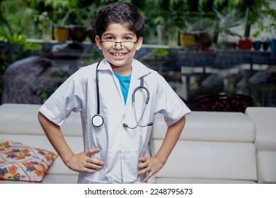 Happy playful young indian boy child wearing doctor uniform wearing stethoscope standing at home. - Powered by Shutterstock