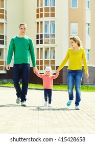 Happy Playing Family Outdoors. Young Parents With A Baby Walking In The Summer. Mom, Dad And Child