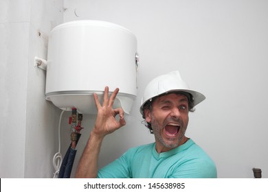 Happy plumber installing an electric water heater