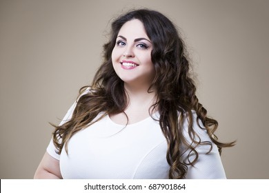 Happy plus size fashion model in casual clothes, fat woman on beige studio background, overweight female body