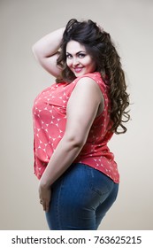 Happy plus size fashion model in casual clothes, sexy fat woman on beige studio background
