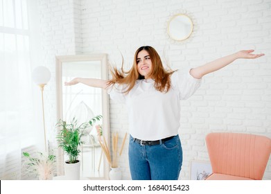 Happy plus size model in jeans and white t-shirt, tosses hair lifestyle. Young plump woman in casual outfit. The body is positive. The concept of one beauty. XXXL fashion