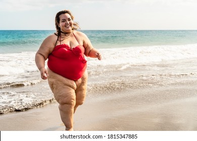 Happy plus size woman running on the beach - Curvy overweight model having fun during vacation in tropical destination - Over size confident person concept