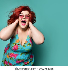 Happy plus-size lady fat woman holds her head with her arms and shouts or loud laughs having good time crazy shopping sale offer mint background