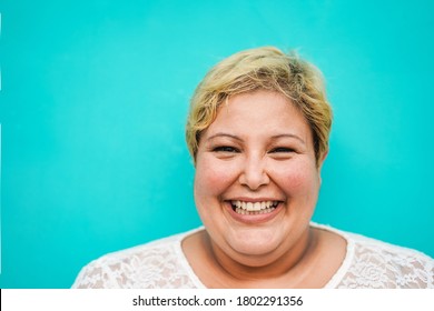 Happy plus-size woman portrait - Curvy overweight lady with turquoise background - Emancipation and confident concept - Focus on face