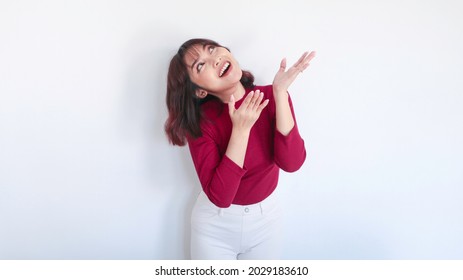 happy pointing above of Asian beautiful girl with red shirt in white background