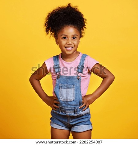 Happy, portrait and child with a smile on face isolated on a yellow background. Cute young girl kid model with happiness, carefree and positive attitude in studio with hands on hips and mockup
