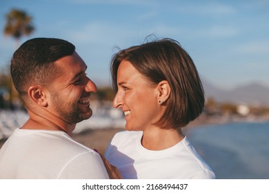 Happy Portrait Couple In Love On The Beach. Family. Diverse Couple On Summer Vacation. Portrait Beautiful Healthy Young Adults Girlfriend And Boyfriend Hugging Happy.