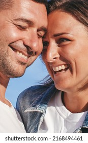 Happy Portrait Couple In Love On The Beach. Family. Diverse Couple On Summer Vacation. Portrait Beautiful Healthy Young Adults Girlfriend And Boyfriend Hugging Happy.