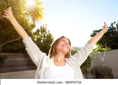 Happy Portrait Of Smiling Older Woman With Arms Outstretched