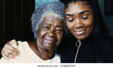 Happy portrait of young African American granddaughter with arm around her grandmother posing for camera, close-up faces of intergenerational family members embrace - Powered by Shutterstock