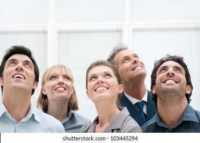 Happy positive business group looking up with dreaming expression