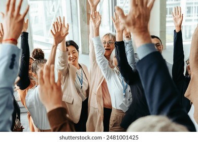 Happy and positive business team raising hands and celebrating success together in a modern office setting. - Powered by Shutterstock