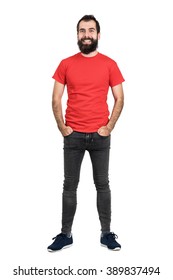 Happy positive friendly bearded man in red t-shirt and tight jeans laughing at camera. Full body length portrait isolated over white studio background.