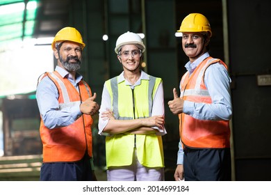 Happy Positive Indian Engineers Wearing Helmet And Vest Standing  At Industrial Factory, Smiling Confident  Male And Female Worker With Hard Hat  Do Thumbs Up Looking At Camera, Skill India. 