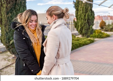 Happy and positive moments of two elegant girls walking down the street in the city. Portrait of young girls having fun, smiling, charming moments, best friend. Concept of friendship and love
