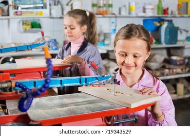 Happy  Positive Schoolgirls Learning To Carve Wood During Arts And Crafts Class