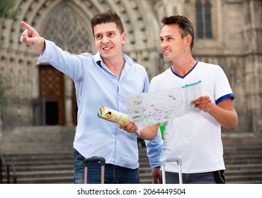 Happy positive smiling male tourist couple looking at the map in the city - Powered by Shutterstock