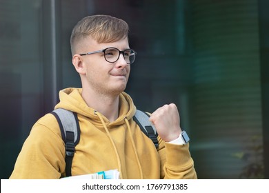 Happy Positive Successful Handsome College Student, Cheerful Pupil, Young Man Smiling With Books, Textbooks, Glasses Look At Result List. Smart Boy Passed University Exam, Celebrating Victory, Triumph